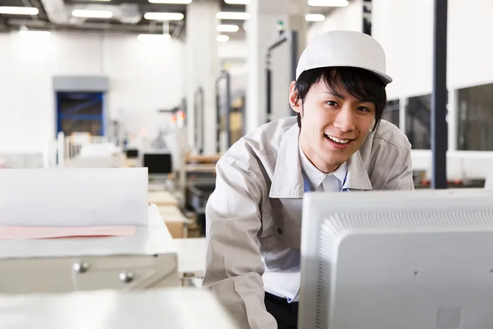 パソコンに向かう笑顔の若手技術者